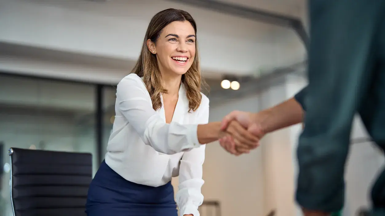 Young woman shaking hands with person