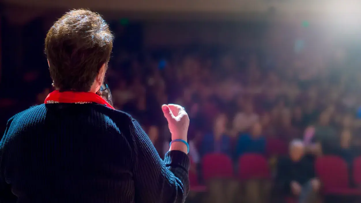 A woman speaking at a large conference