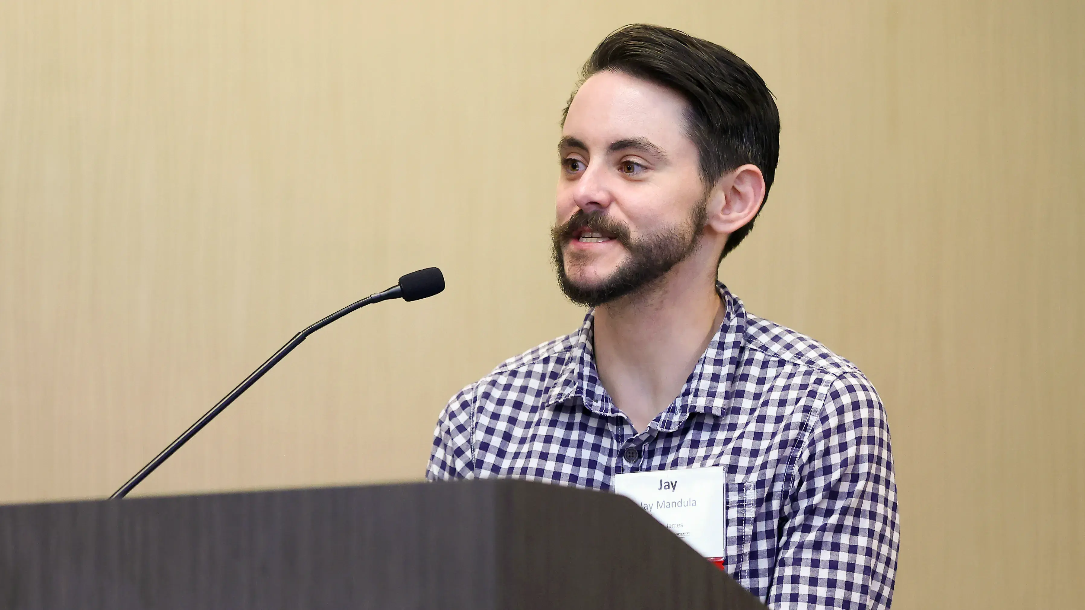 POrtrait of Jay Mandula speaking at a podium