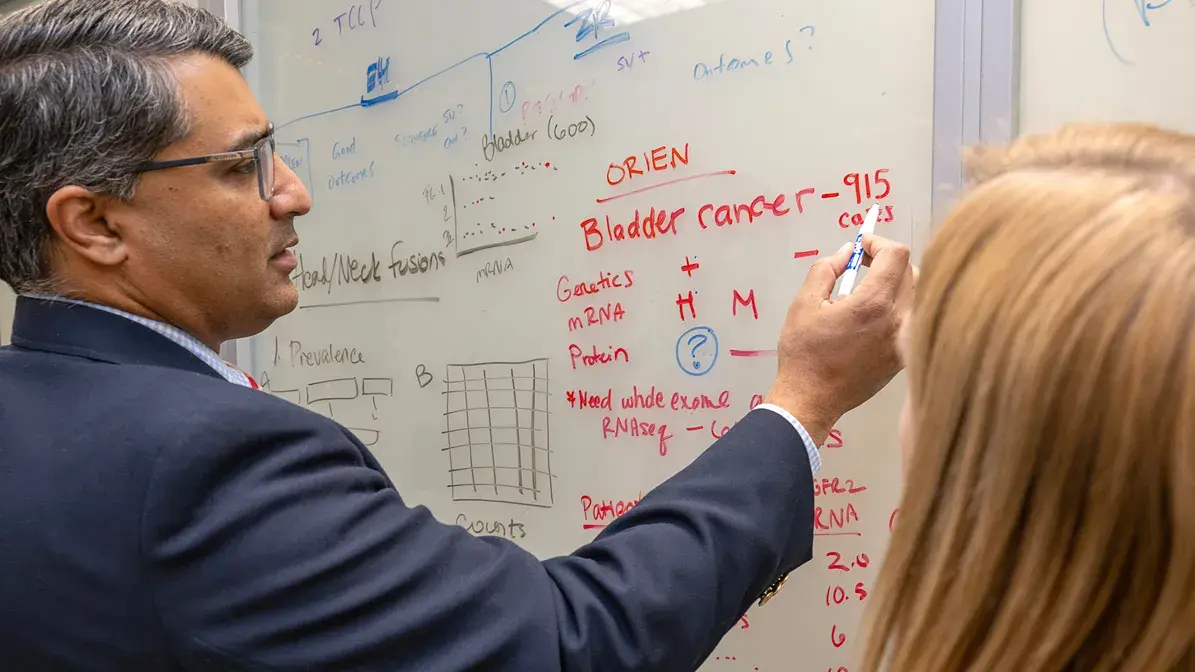 man using a whiteboard to document research progress