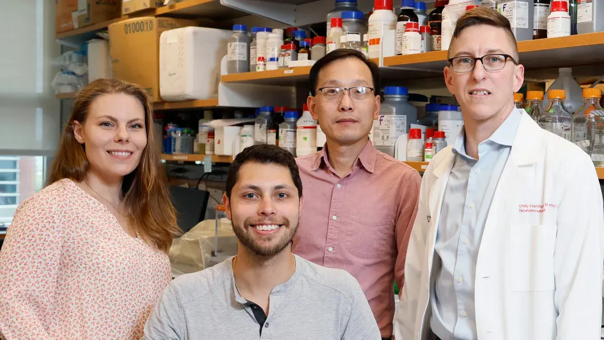 group of five individuals of different ages and ethnicities in a laboratory setting