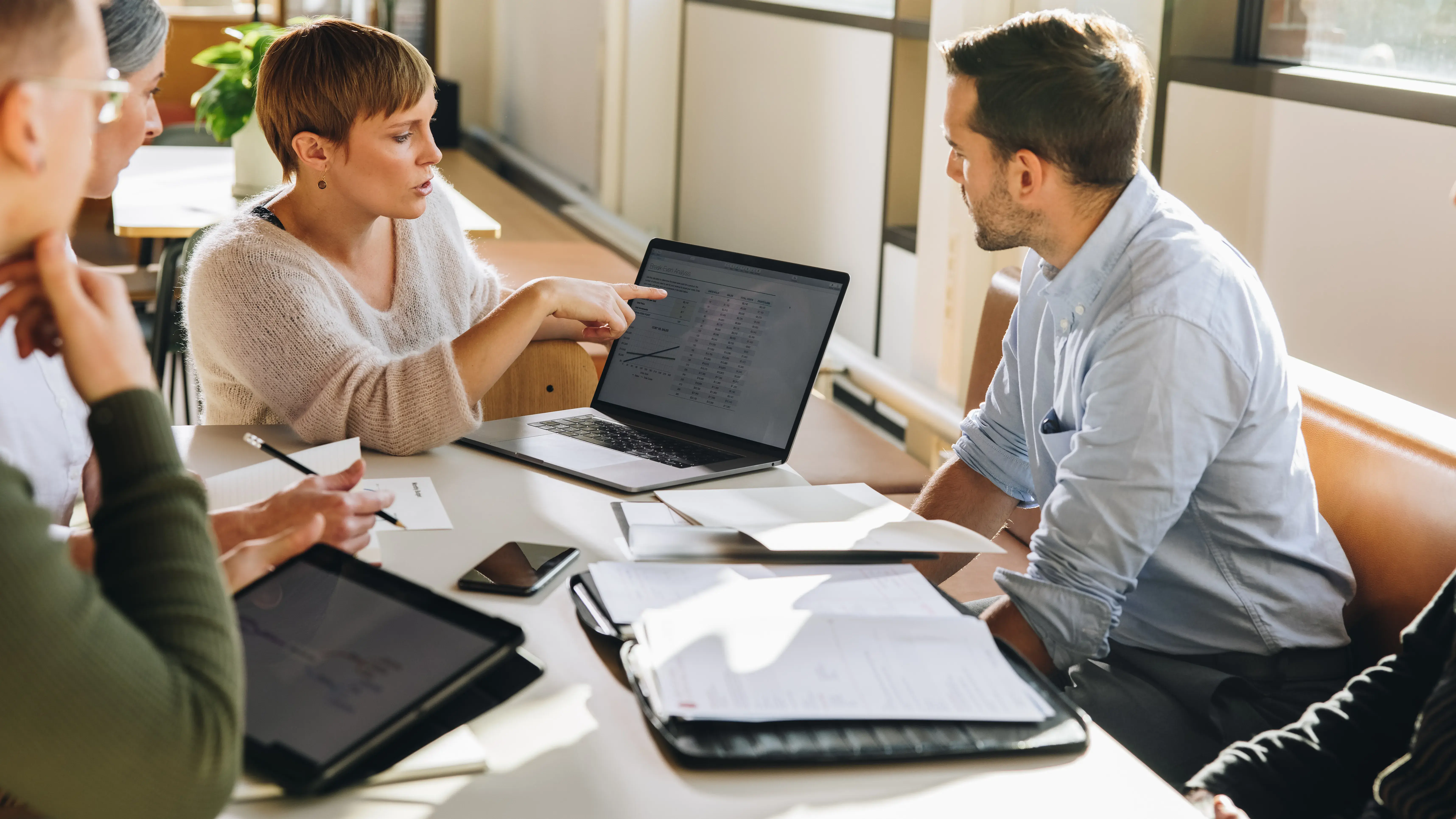 Female executive showing data to team in meeting