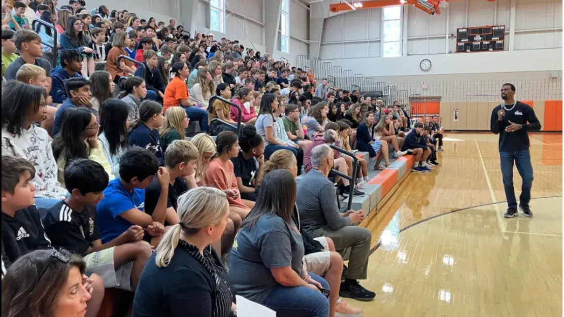 Devon speaking to students in the gym
