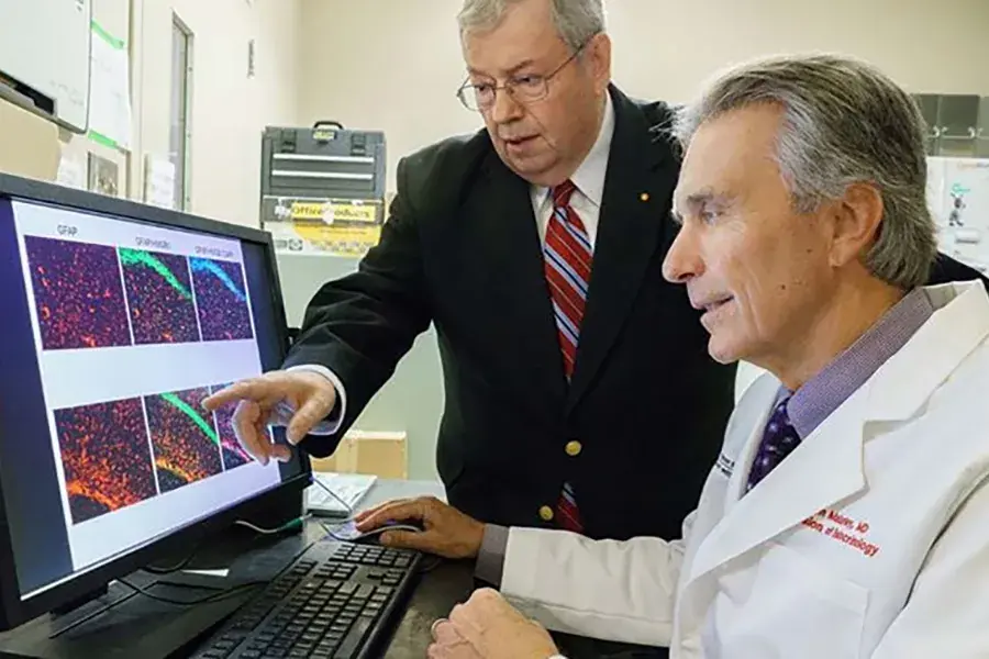 two men looking at a computer screen with multiple scan images on it